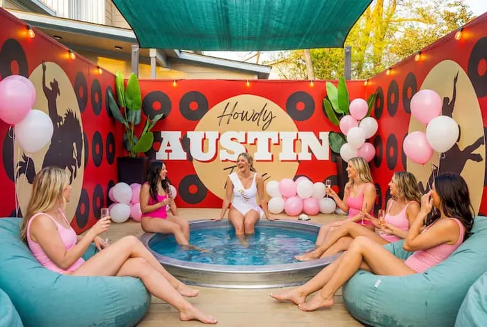 Cowboy pool party in front of the Howdy Austin mural